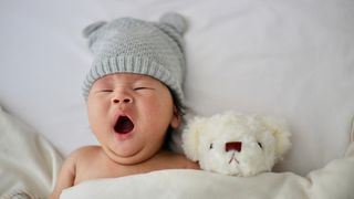 Baby mit Mütze und Kuscheltier