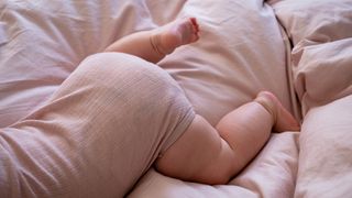 Ein Baby liegt bäuchlings auf einer Bettdecke