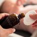 Mutter trägt bumwell Baby-Wundschutz Liquid auf Wattepad auf - Bio-Babypflege mit Schwarztee und Eichenrinde
