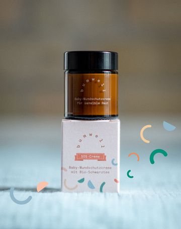 bumwell SOS Baby-Wundschutzcreme Packaging Design mit bunten grafischen Elementen auf Wickeltisch