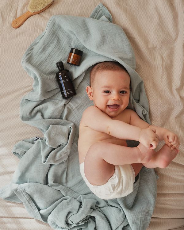 Baby auf Bett mit bumwell Baby-Wundschutz Liquid und bumwell Baby-Wundschutzcreme