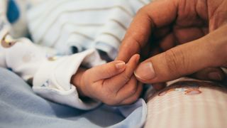 Mama hält Babys Hand