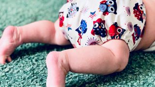 Eine bunte Stoffwindel an einem wenige Monate alten Baby